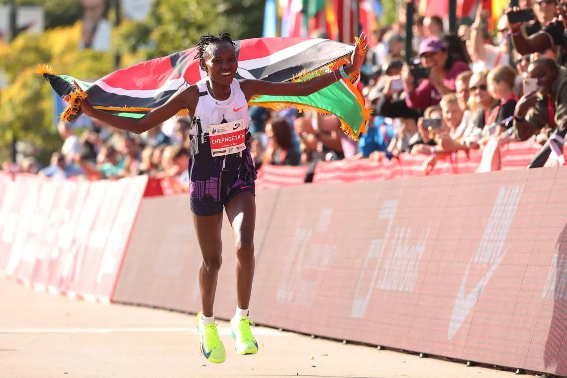 Ruth Chepngetich of Kenya celebrating after crossing the finish line to win the 2024 Chicago Marathon professional women's division and setting a new world record with a time of 2:09:56.