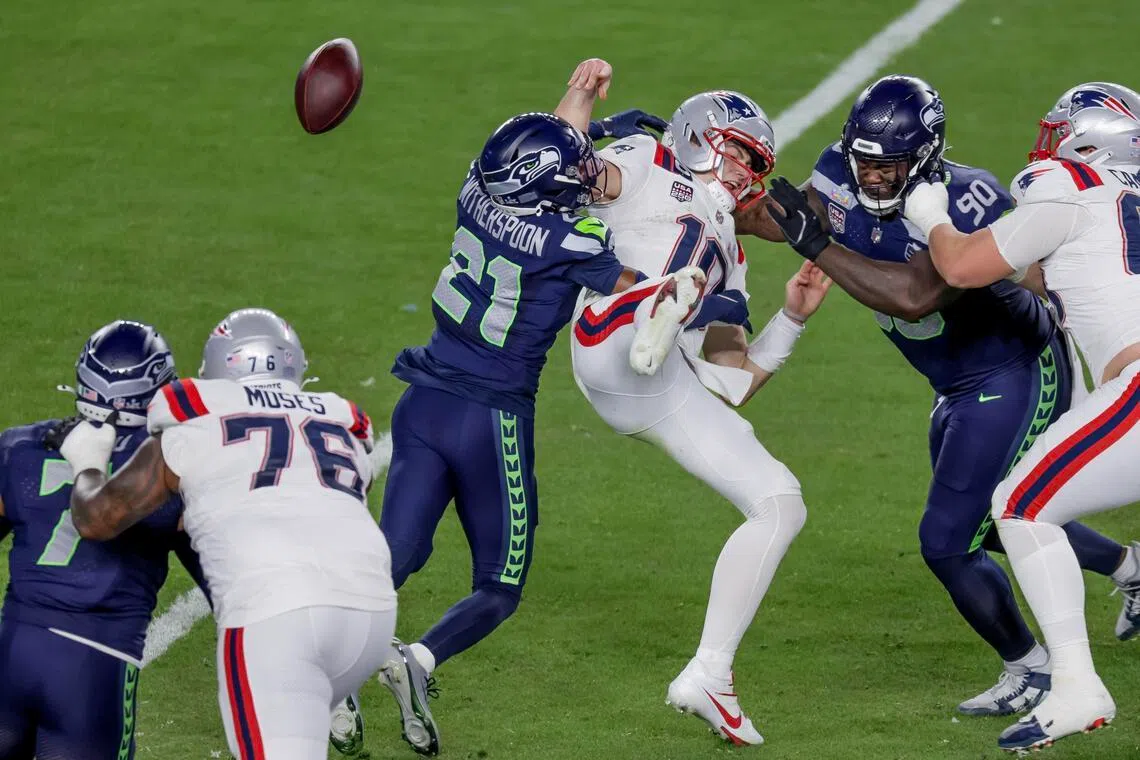 New England Patriots quarterback Drake Maye fumbling the ball under pressure from Seattle Seahawks cornerback Devon Witherspoon (centre) and defensive tackle Jarran Reed during the second half of Super Bowl LX. Seattle won the game 29-13 at the Levi's Stadium in Santa Clara, California, on Feb 8, 2026.
