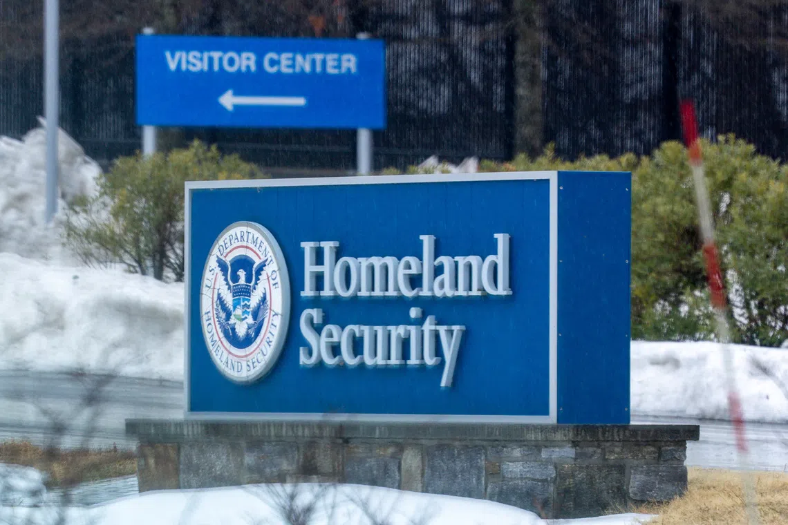 A sign for the Department of Homeland Security and a directional sign for the Visitor Center in a snowy outdoor setting.