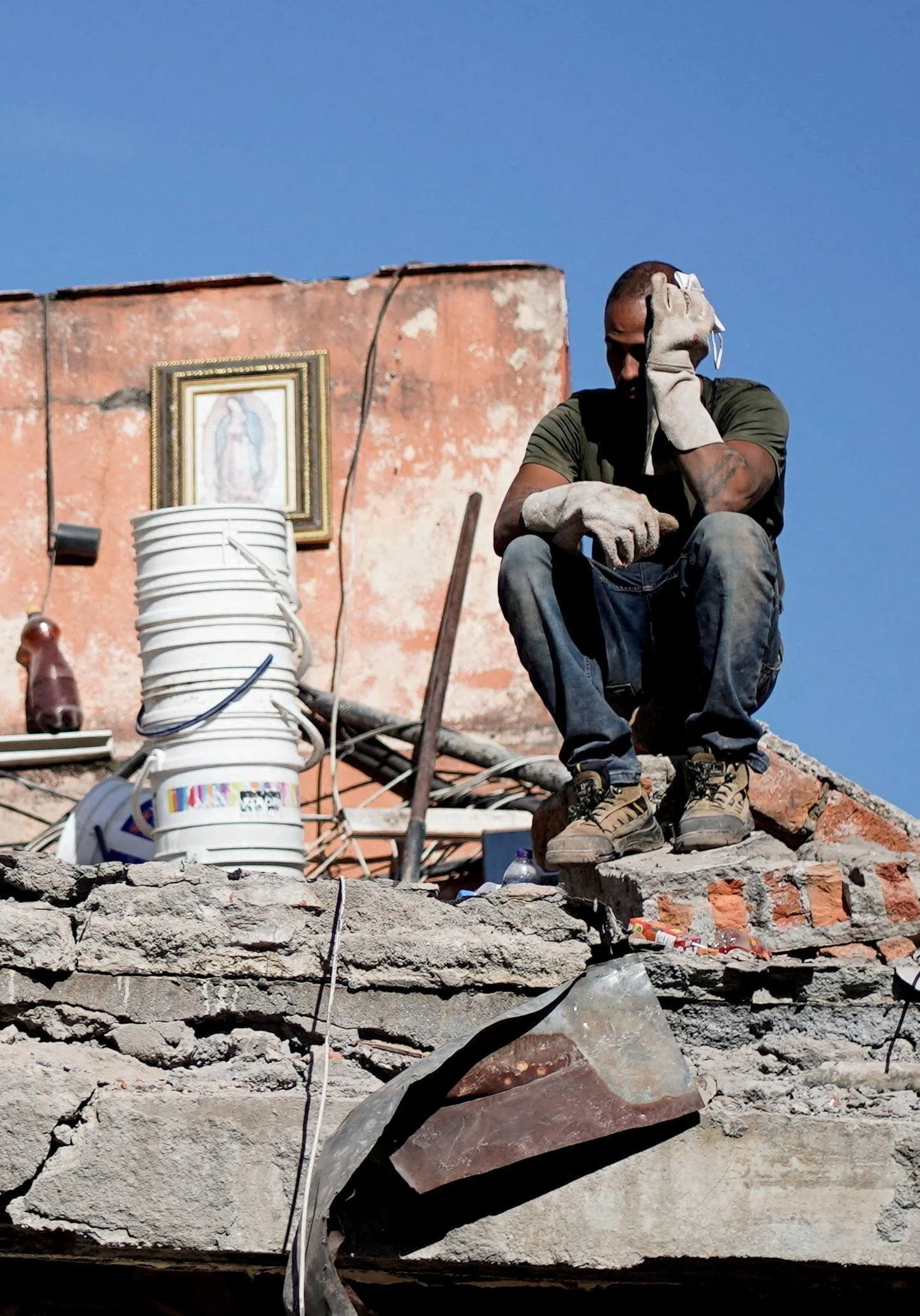 A man sitting amid the rubble as people search for earthquake survivors in Cali, Colombia, on Aug 11.
