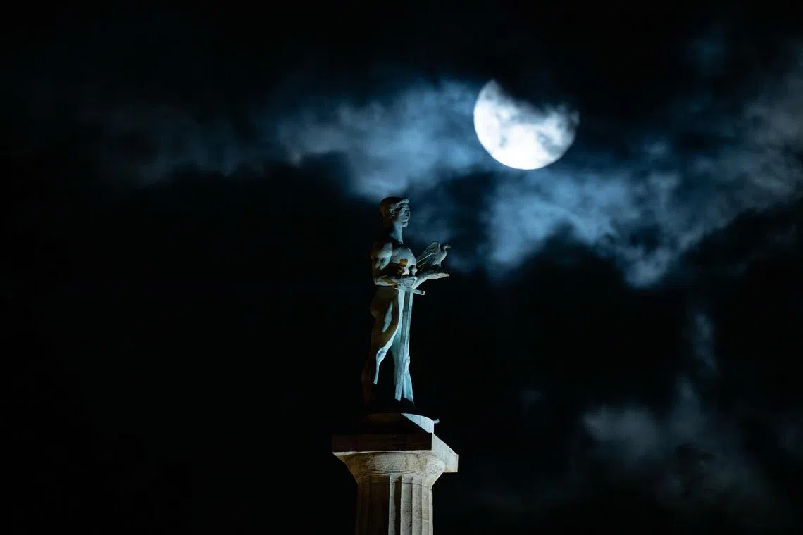 The "Blue Supermoon", the second full moon of a calendar month, rising behind the landmark monument 'The Victor' ('Pobednik' in Serbian) in Belgrade, on Aug 30, 2023. 