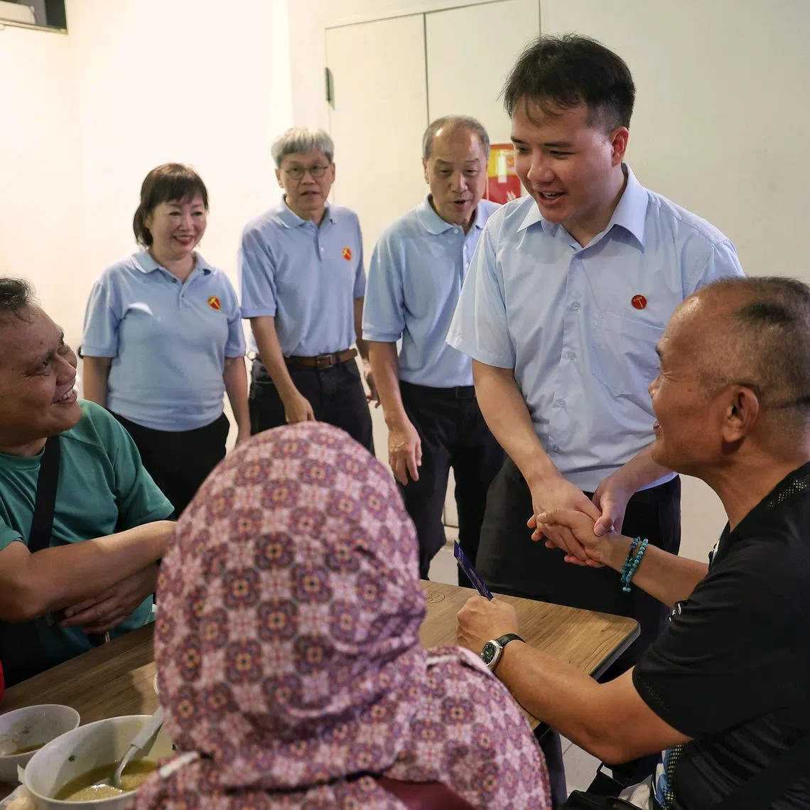 WP Jalan Kayu SMC candidate Andre Low (right), accompanied by Mr Low Thia Khiang (2nd from left) and Mr Png Eng Huat, interacting with residents during a walkabout at Fernvale Hawker Centre and Market on April 27.