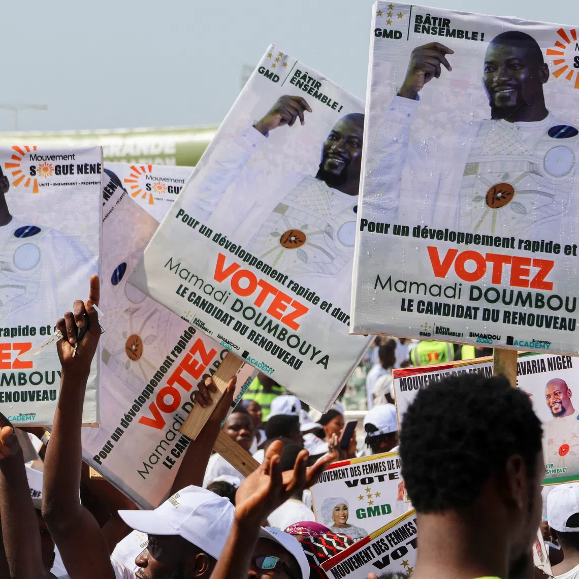 Supporters of Guinean leader and presidential candidate Mamadi Doumbouya hold posters of him, as they take part in his final campaign rally at the Palais du Peuple in Conakry, Guinea December 25, 2025. REUTERS/Souleymane Camara