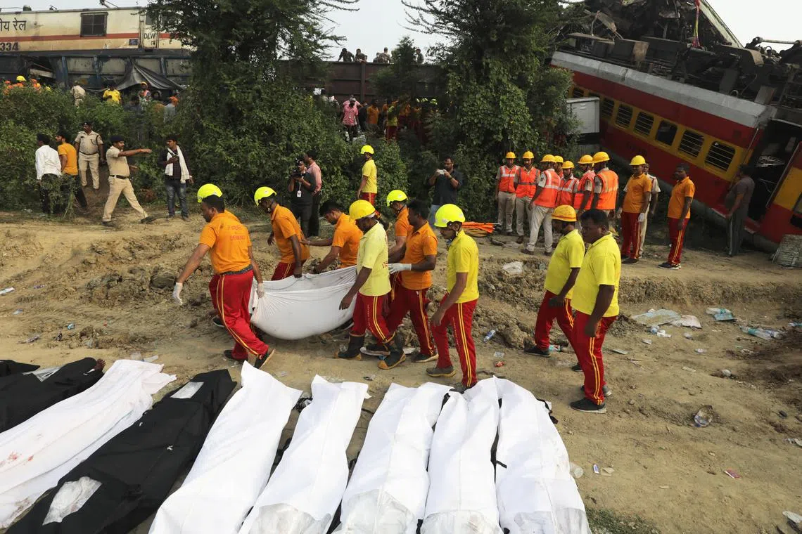 Victims killed in the accident are covered with sheets, as rescue officials continue their work in Odisha, Balasore.