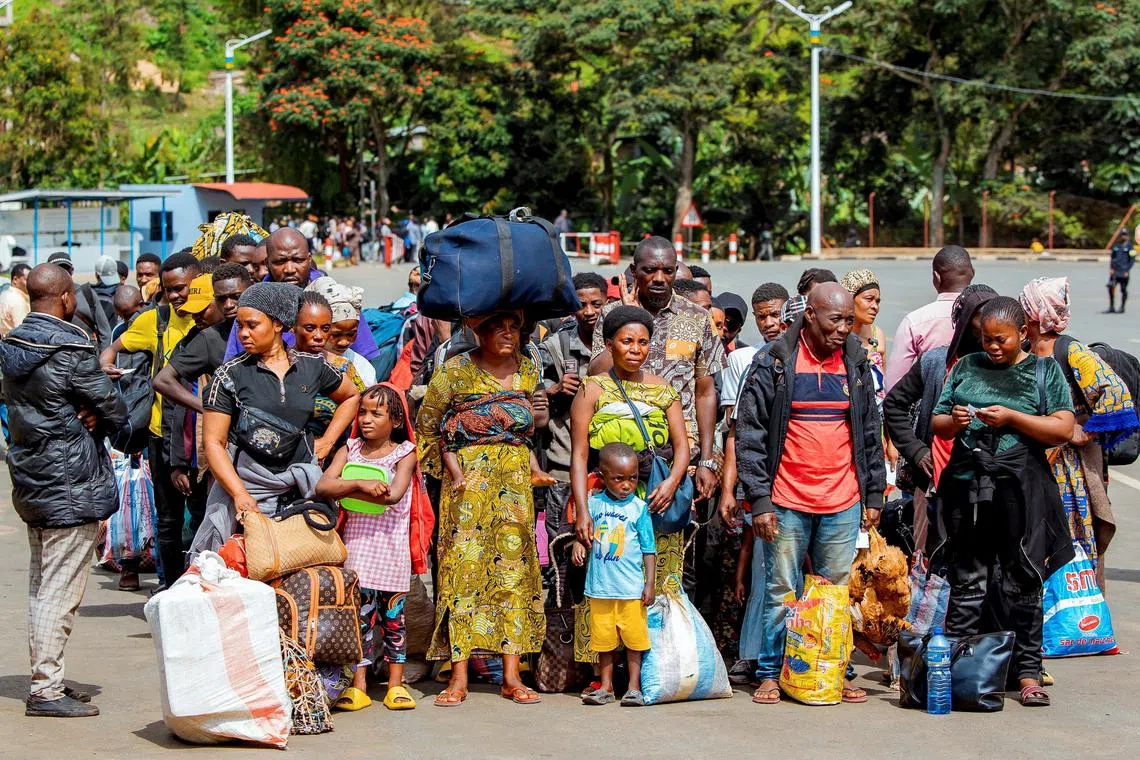 FILE PHOTO: Congolese civilians who fled from Bukavu, eastern Democratic Republic of Congo following clashes between M23 rebels and the Armed Forces of the Democratic Republic of the Congo (FARDC), carry their belongings as they gather at the Rusizi border crossing point to return home, in Rusizi district, Rwanda, February 17, 2025. REUTERS/Stringer/File Photo