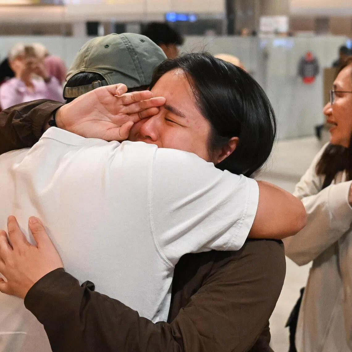 Ms Amanda Er, 31, healthcare worker, tearing up as she is greeted by a loved one, after her RSAF repatriation flight from Saudi Arabia, at the arrival hall of Changi Airport Terminal 2 on  March 11, 2026. ST PHOTO: SHINTARO TAY