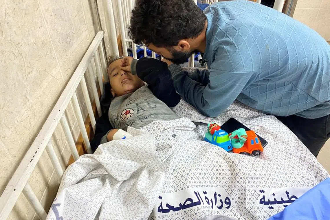 Palestinian boy Ahmad Shabat, 4, who was subjected to two Israeli airstrikes, becoming an orphan in the first one that killed his parents, and losing his 2 lower limbs in the second, is looked after by his uncle, at Shuhada al-Aqsa hospital in the central Gaza Strip November 14, 2023. REUTERS/Doaa Ruqaa