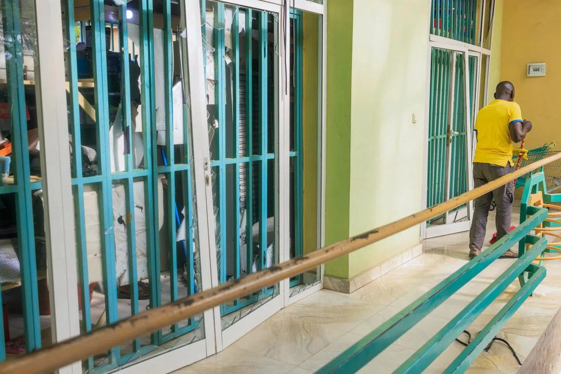 A worker cleans the debris of broken glass after the impact from the explosion following the explosions at a military ammunition store with the blasts lasting several, according to comments from residents, prompting terrified residents to seek shelter, in Bujumbura, Burundi, April 1, 2026. REUTERS/Evrard Ngendakumana