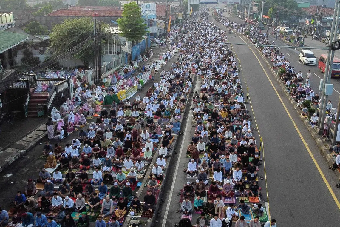 Muslims attending Eid al-Fitr prayers, marking the end of the holy month of Ramadan, on a street in Bekasi, West Java, on April 10, 2024. 