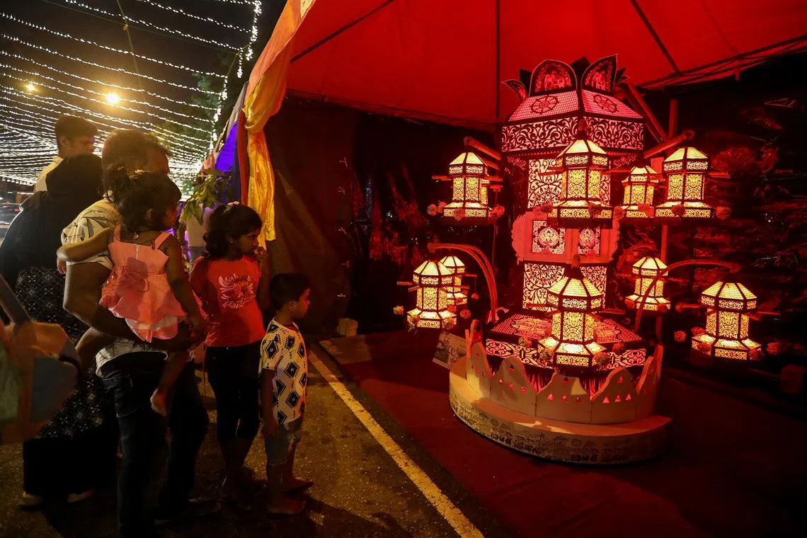 People looking at Vesak Day illuminations and decorations during Vesak celebrations in Colombo, Sri Lanka, on May 12, 2025. 