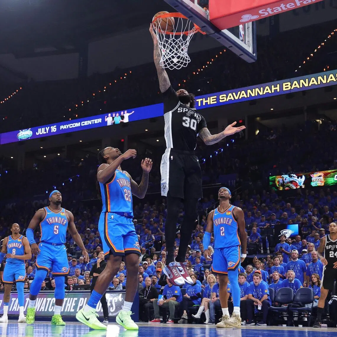 Julian Champagnie of the San Antonio Spurs shoots the ball against Cason Wallace and Shai Gilgeous-Alexander of the Oklahoma City Thunder during the third quarter in Game 1.