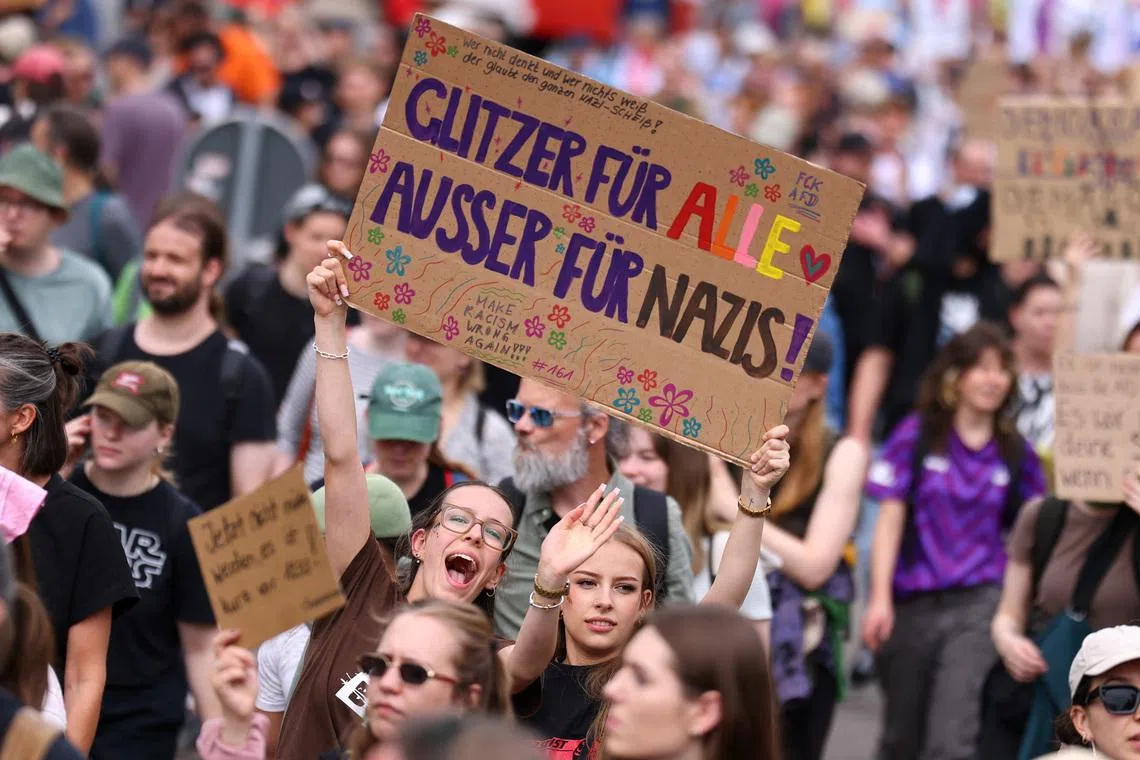 People hold a sign that reads: \"Glitter for everyone, except for Nazis\" during a protest against a two-day party convention of Germany's far-right Alternative for Germany (AfD) party, in Erfurt, Germany, July 4, 2026. REUTERS/Christian Mang