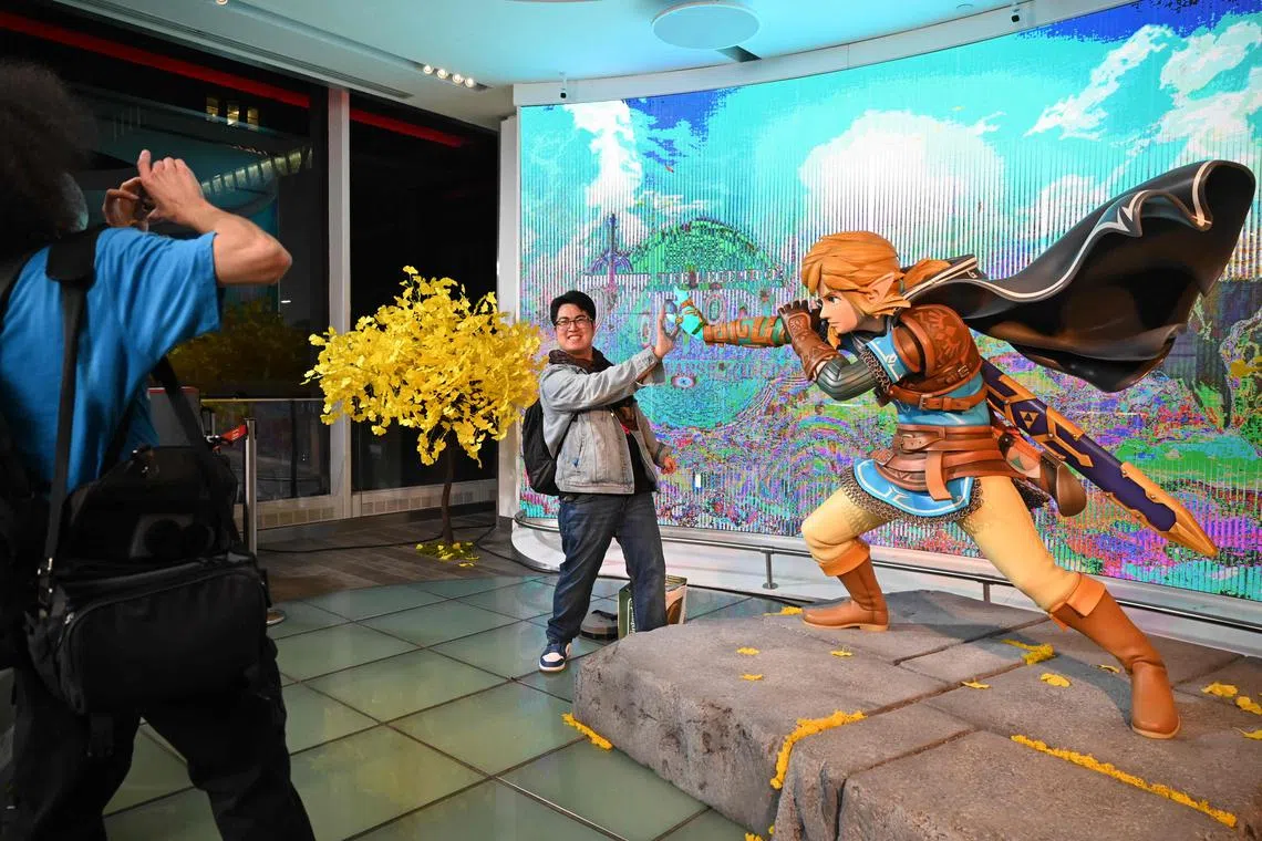 A customer poses for a photo with Zelda's character Link after purchasing the game.