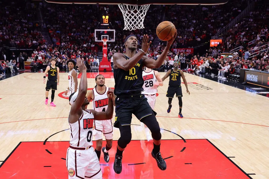 Jimmy Butler of the Golden State Warriors shoots the ball against Aaron Holiday of the Houston Rockets during the second half at Toyota Centre on Feb 13, 2025.