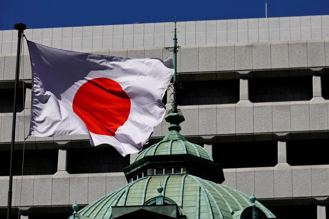 The Japanese national flag waves at the Bank of Japan building in Tokyo. Japan’s central bankers meet this week for a key rate decision.