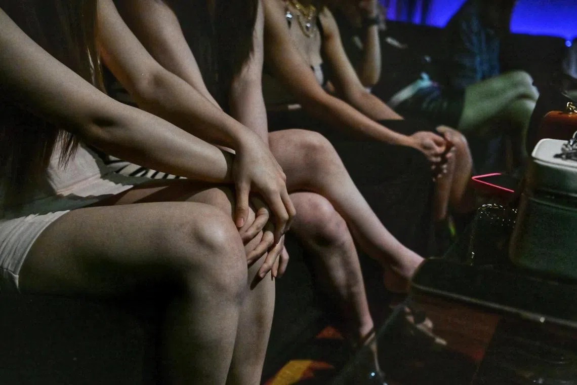 Women being detained in a room after getting arrested during a raid at a public entertainment outlet in Orchard on the night of July 21.