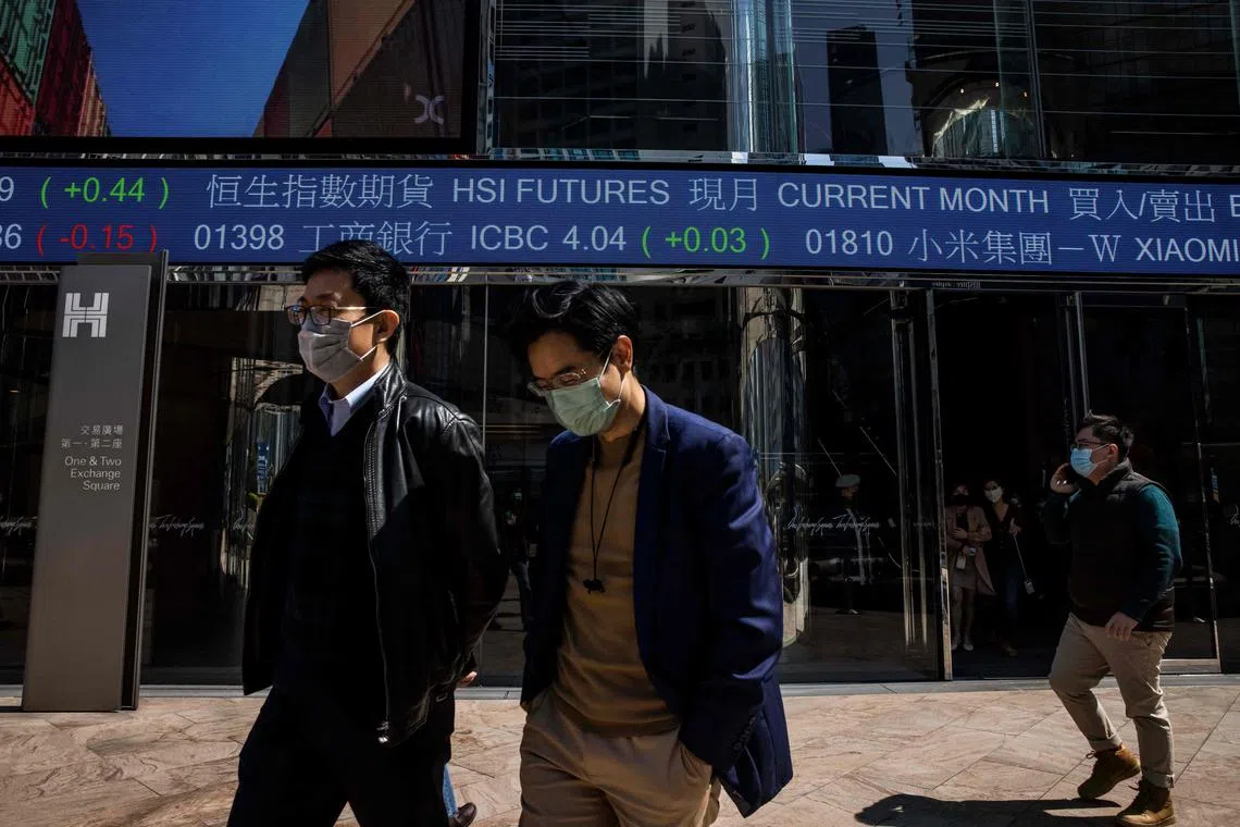 People walk through exchange square outside the Hong Kong Stock Exchange in Hong Kong on February, 2023. (Photo by ISAAC LAWRENCE / AFP)