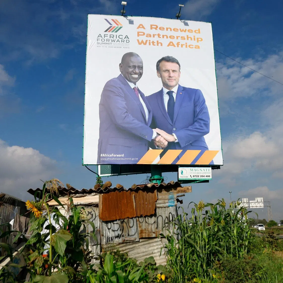 A pedestrian walks near a billboard featuring Kenyan President William Ruto and French President Emmanuel Macron ahead of the \"Africa Forward\" Summit, in the outskirts of Nairobi, Kenya May 7, 2026. REUTERS/Thomas Mukoya
