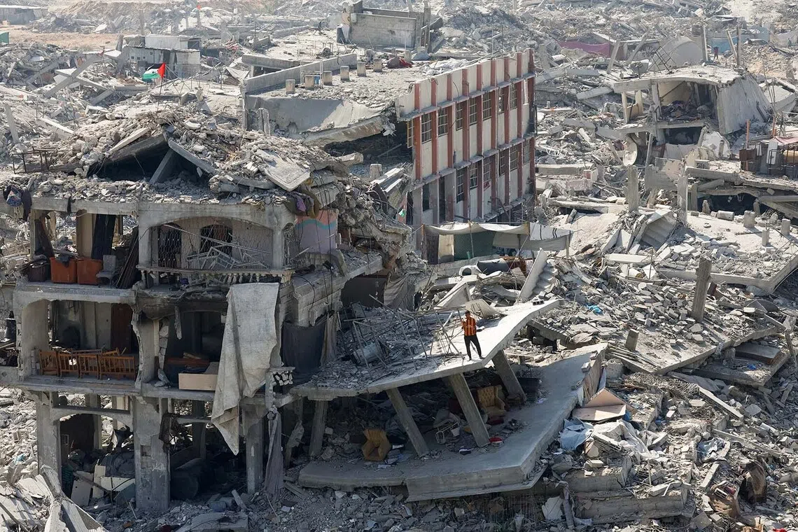A Palestinian standing next to the rubble of destroyed and heavily damaged buildings, amid a ceasefire between Israel and Hamas, in Gaza City, Nov 2, 2025. 