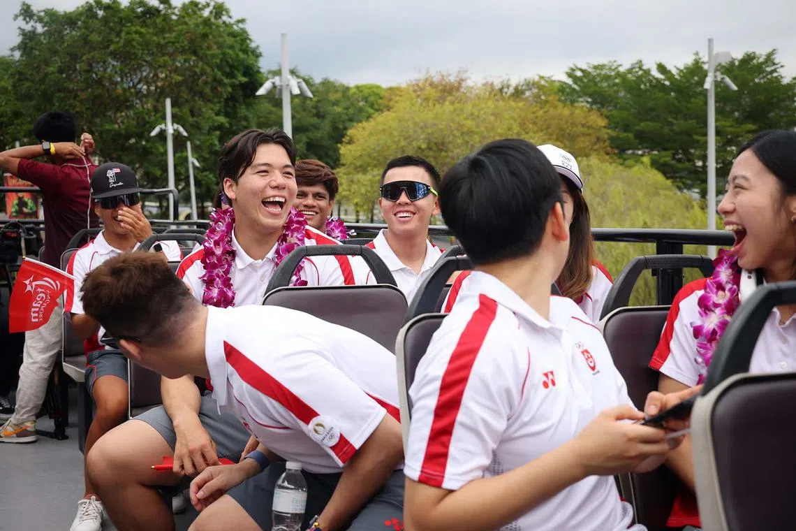 ST20240814_202400800984/dgbus14/Jason Quah Team Singapore?s Paris 2024 Olympian kitefoiler Maximilian Maeder shares a laugh with fellow Olympians as the One Team Singapore celebratory parade begins on Aug 14, 2024. ST PHOTO: JASON QUAH