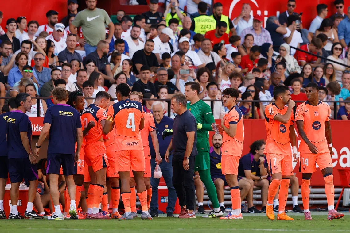 Soccer Football - LaLiga - Sevilla v FC Barcelona - Ramon Sanchez Pizjuan, Seville, Spain - October 5, 2025 General view of FC Barcelona players and coach Hansi Flick during a water break REUTERS/Marcelo Del Pozo