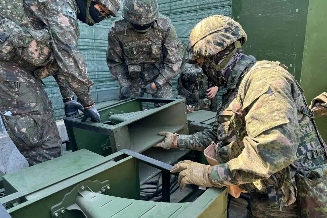 FILE PHOTO: South Korean soldiers work on a loudspeaker that is set up for propaganda broadcasts during a military drill near the demilitarized zone separating the two Koreas in Paju, South Korea, in this handout picture provided by the Defense Ministry and released on June 9, 2024.   The Defense Ministry/Handout via REUTERS/File Photo
