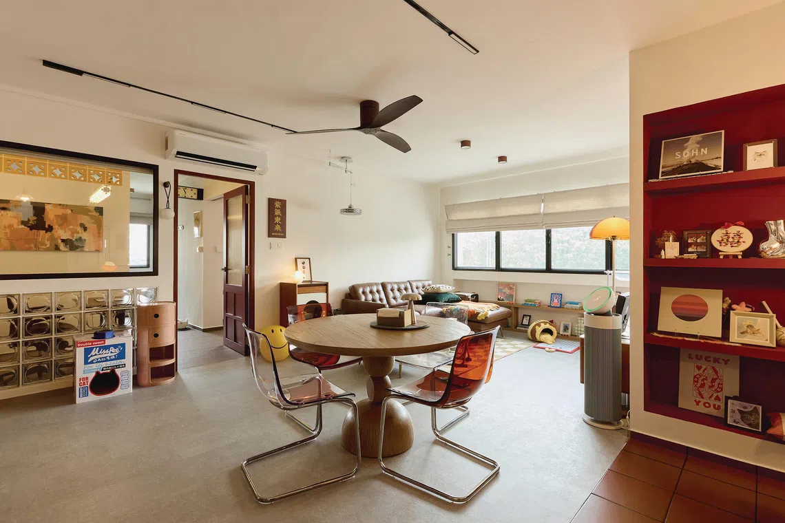 The open-concept living and dining area hints at a Mid-century Modern vibe with its warm palette and funky decor.