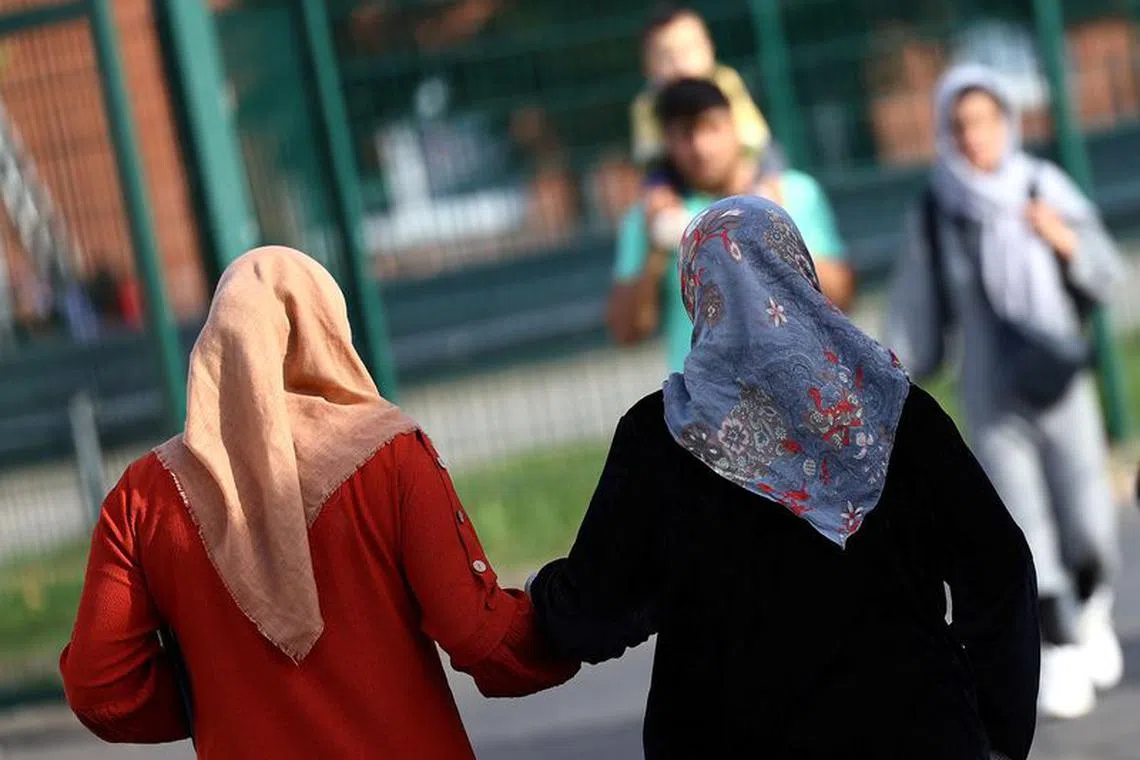 Refugees walk at the first reception center for refugees in Giessen, Germany, October 11, 2023. REUTERS/Kai Pfaffenbach