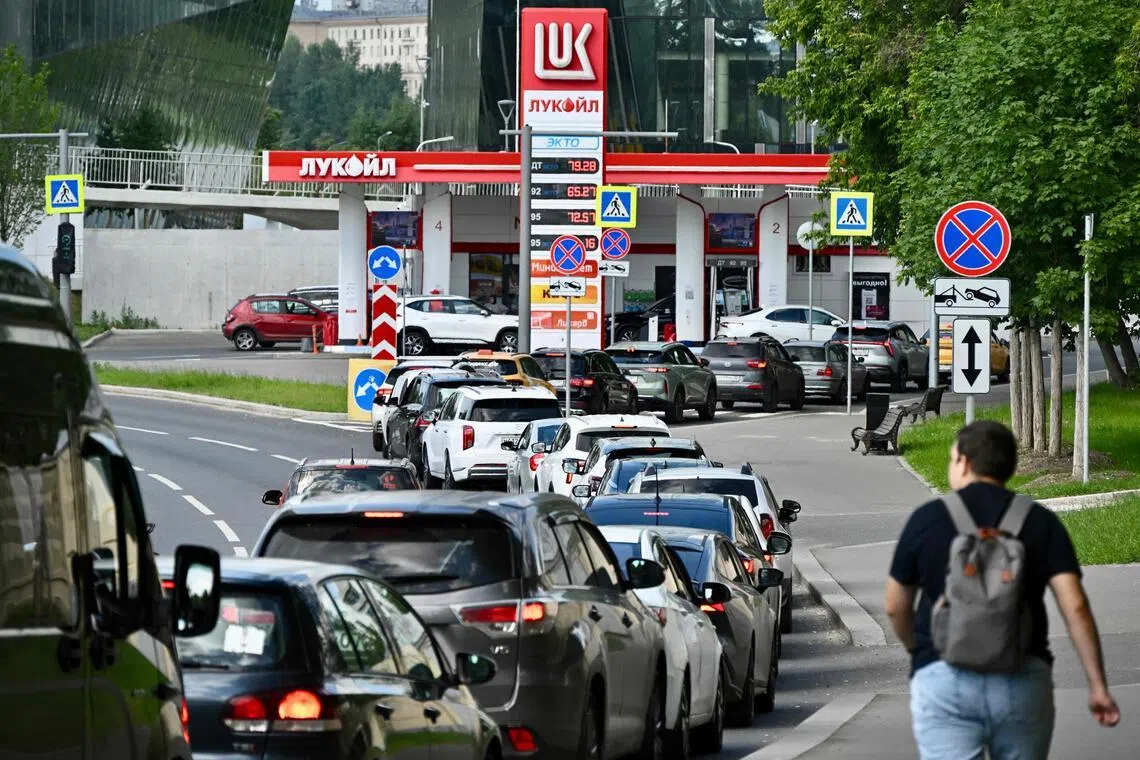 People queue to refuel their cars at a Lukoil petrol station in Moscow, on June 30.