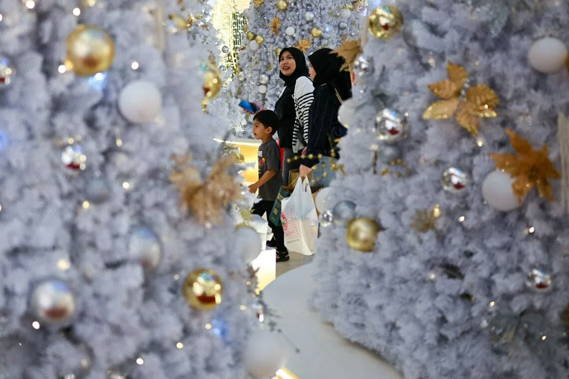 Shoppers walking around Christmas trees at a mall in Kuala Lumpur, on Dec 9, 2025. 