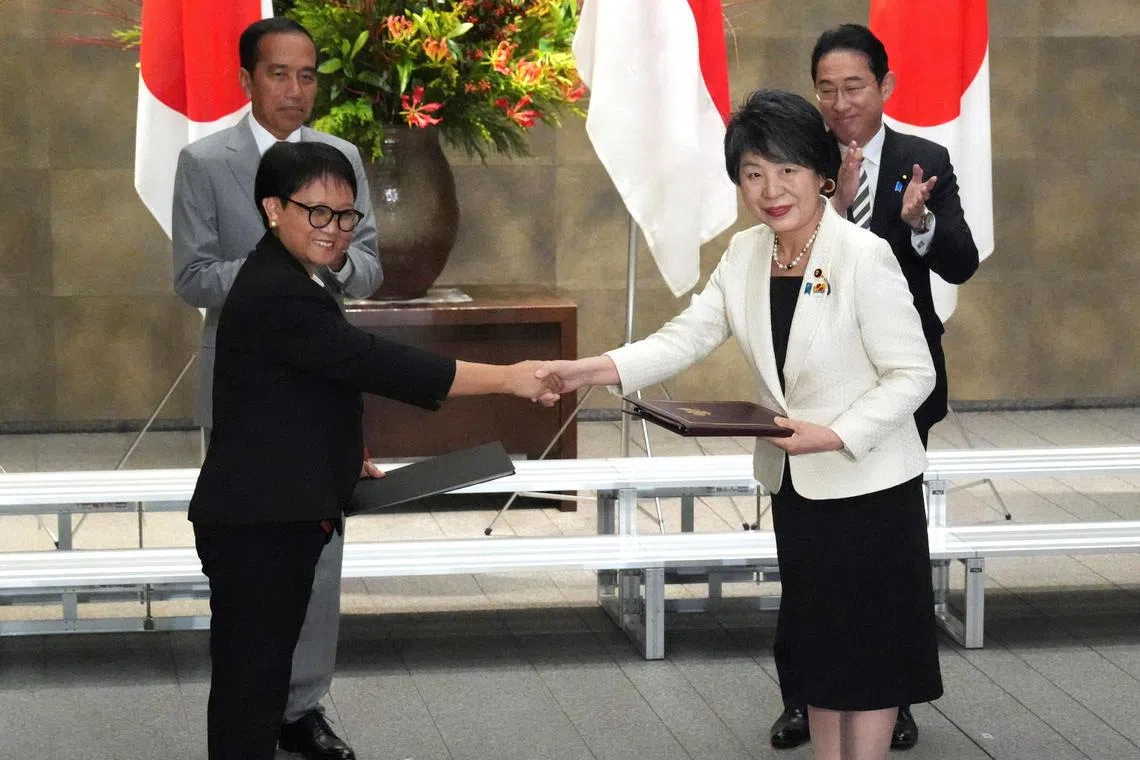 Japanese Foreign Minister Yoko Kamikawa and Indonesia's Foreign Minister Retno Marsudi shake hands during a document exchange ceremony at the prime minister's official residence in Japan.  