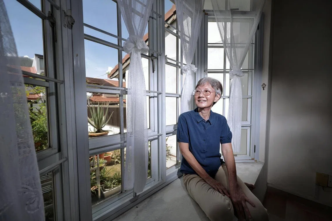 65-year-old retired teacher Mdm Yau Li Heong, whose left eye underwent corneal transplant, looking out of the window at home on March 26, 2024. Mdm Yau recalled the joy she experienced after the transplant, when she was able to see the view beyond her window. Story on increase in corneal transplant, but demand still outpaces supply.