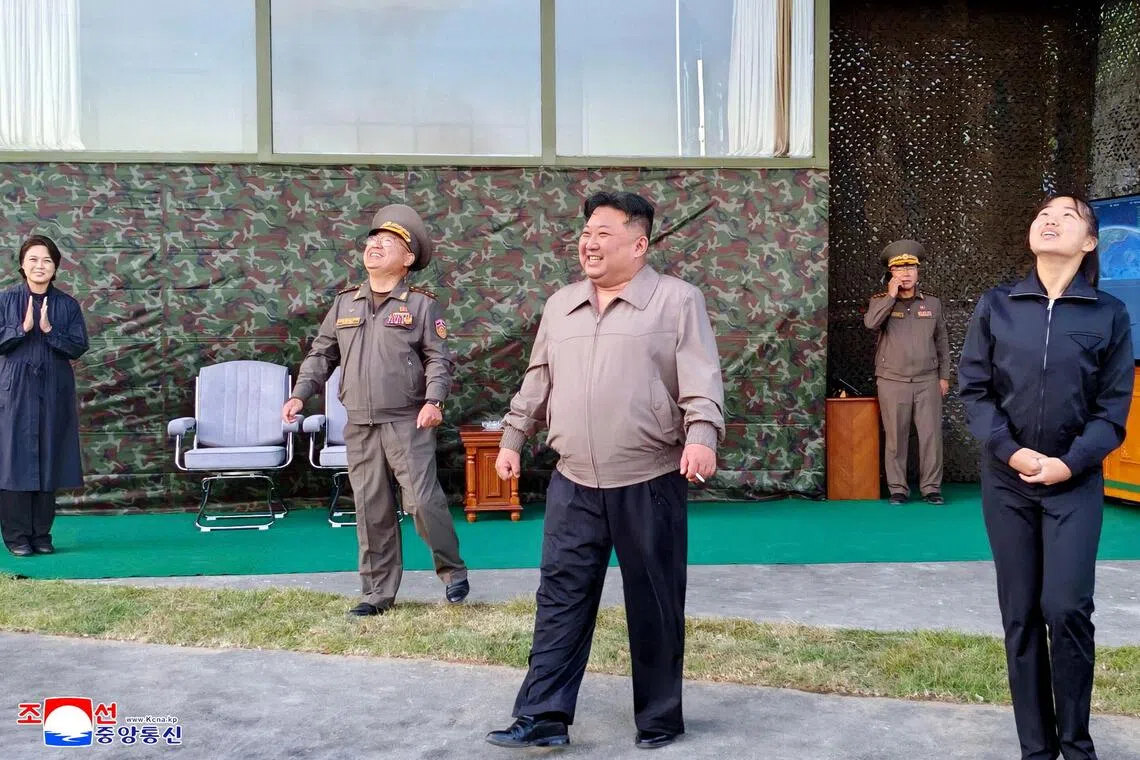 North Korean leader Kim Jong Un (centre), accompanied by his daughter Kim Ju Ae (right), oversees the firing of an intermediate-range missile during a drill on Oct 3.