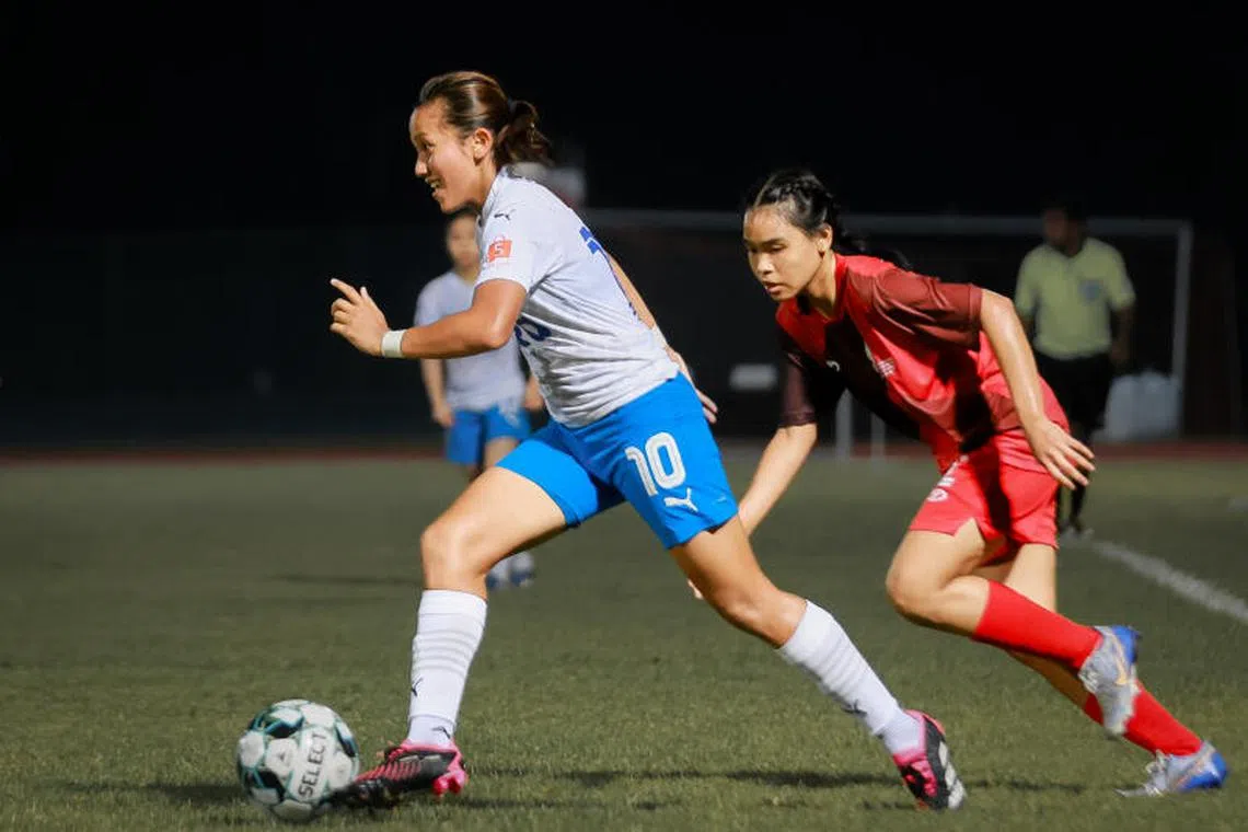 Lion City Sailors' two-goal forward Izzati Rosni advancing with the ball as Police SA's Elyssa Qistina tracks back.