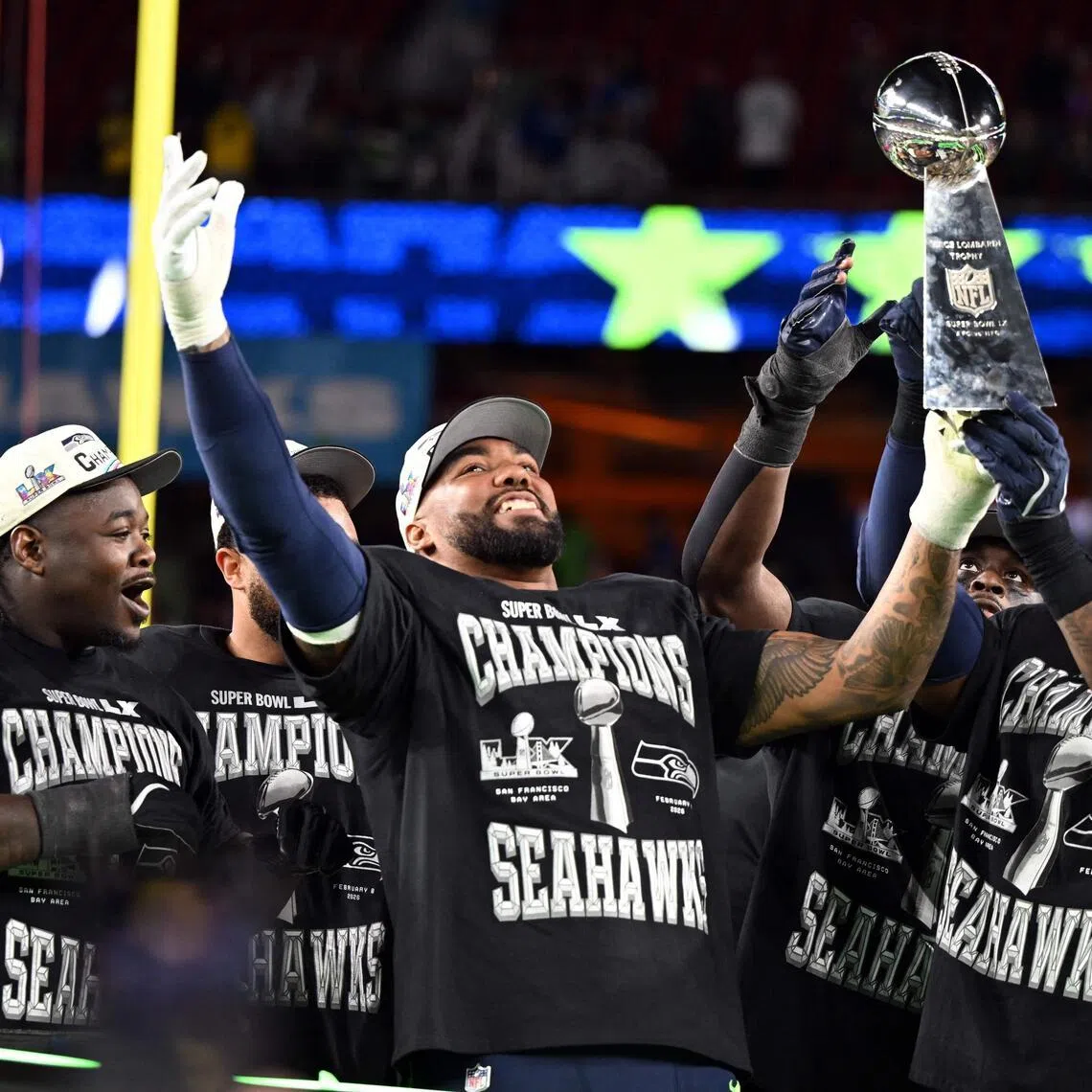 Seattle Seahawks' players celebrate with the Vince Lombardi Trophy after defeating the New England Patriots during Super Bowl LX at Levi's Stadium in Santa Clara, California.