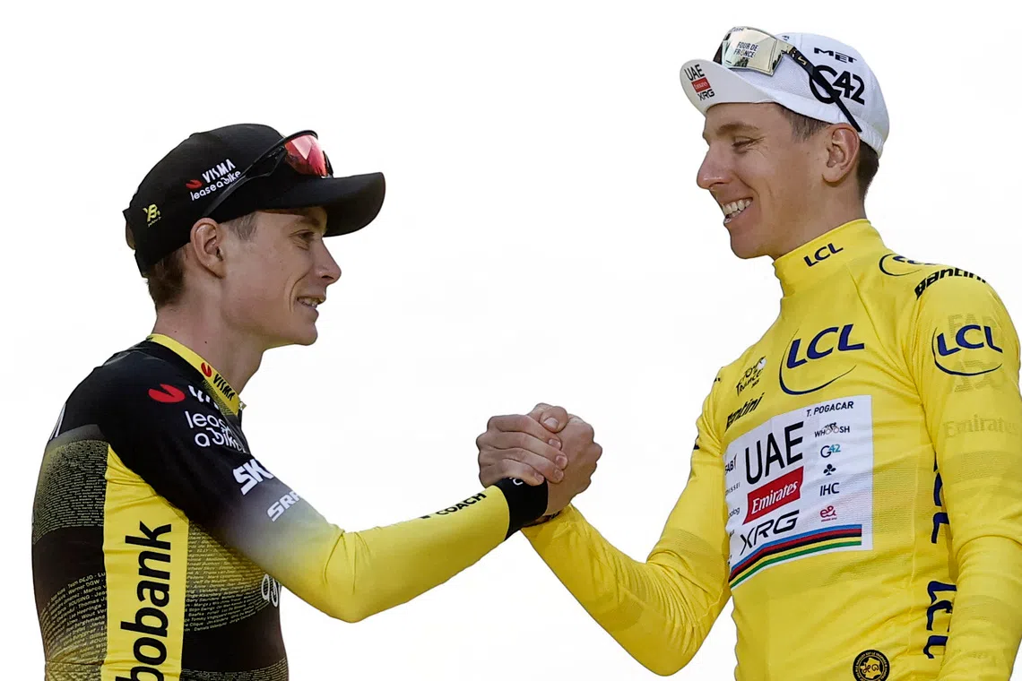 Cycling - Tour de France - Stage 21 - Mantes-la-Ville to Paris - Paris, France - July 27, 2025 Second placed Team Visma | Lease a Bike's Jonas Vingegaard shakes hands with UAE Team Emirates XRG's Tadej Pogacar on the podium as he wears the yellow jersey after winning the Tour de France REUTERS/Benoit Tessier