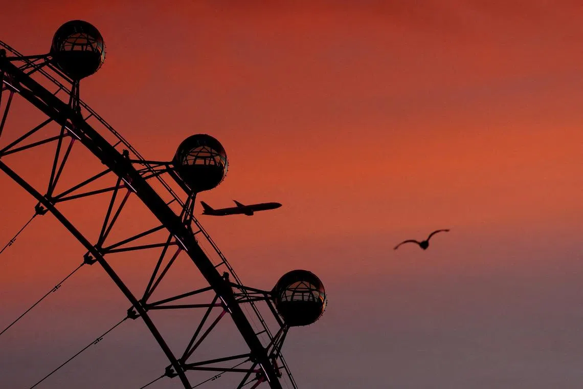 A plane flying past the London Eye in London, Britain, Nov 22, 2023.