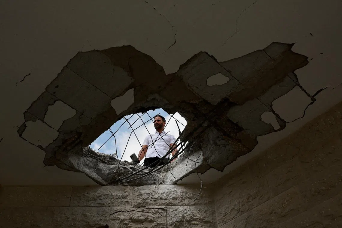 FILE PHOTO: An official property surveyor assesses the damage to a residential building following a direct-hit from a projectile, after Hezbollah launched hundreds of rockets and drones towards Israel in what the Iranian-backed movement said was a response to the assassination of a senior commander in Beirut last month, in northern Israel August 25, 2024. REUTERS/Ammar Awad/File Photo