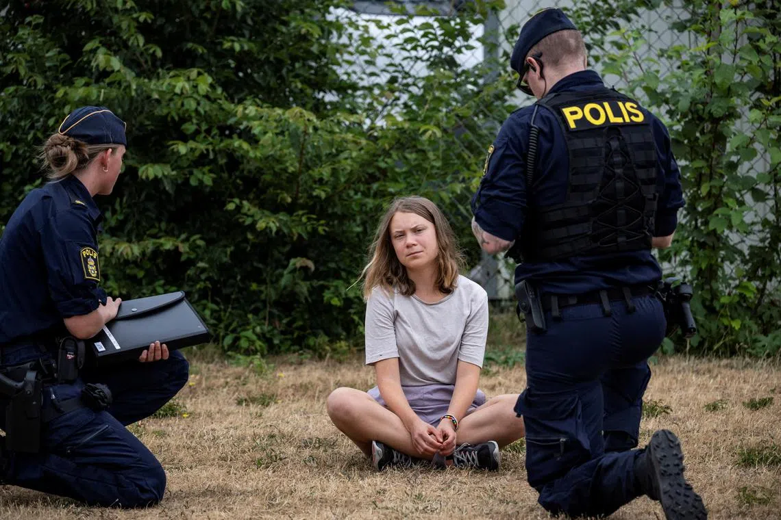 Police talk to Ms Thunberg as they move climate activists from the organisation Ta Tillbaka Framtiden, who are blocking the entrance to Oljehamnen in Malmo, Sweden on June 19. 