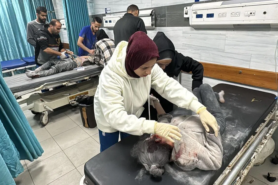 A woman comforts an injured young girl as others surround another young victim inside the Kamal Adwan hospital in Beit Layia in the northern Gaza Strip on Nov 21.