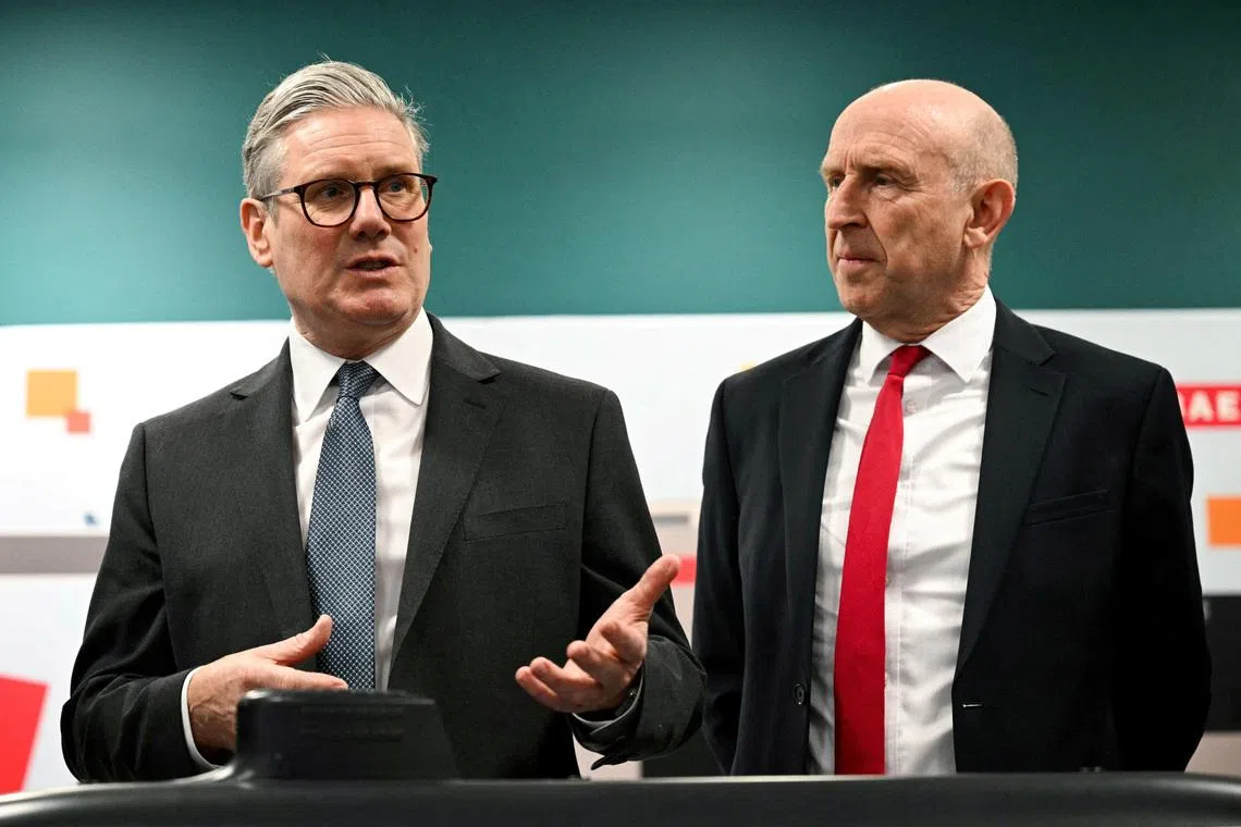 FILE PHOTO: Britain's Prime Minister Keir Starmer and Britain's Defence Secretary John Healey meet with BAE system apprentices during a joint visit in Barrow-in-Furness, Britain, on March 20, 2025.     OLI SCARFF/Pool via REUTERS/File Photo