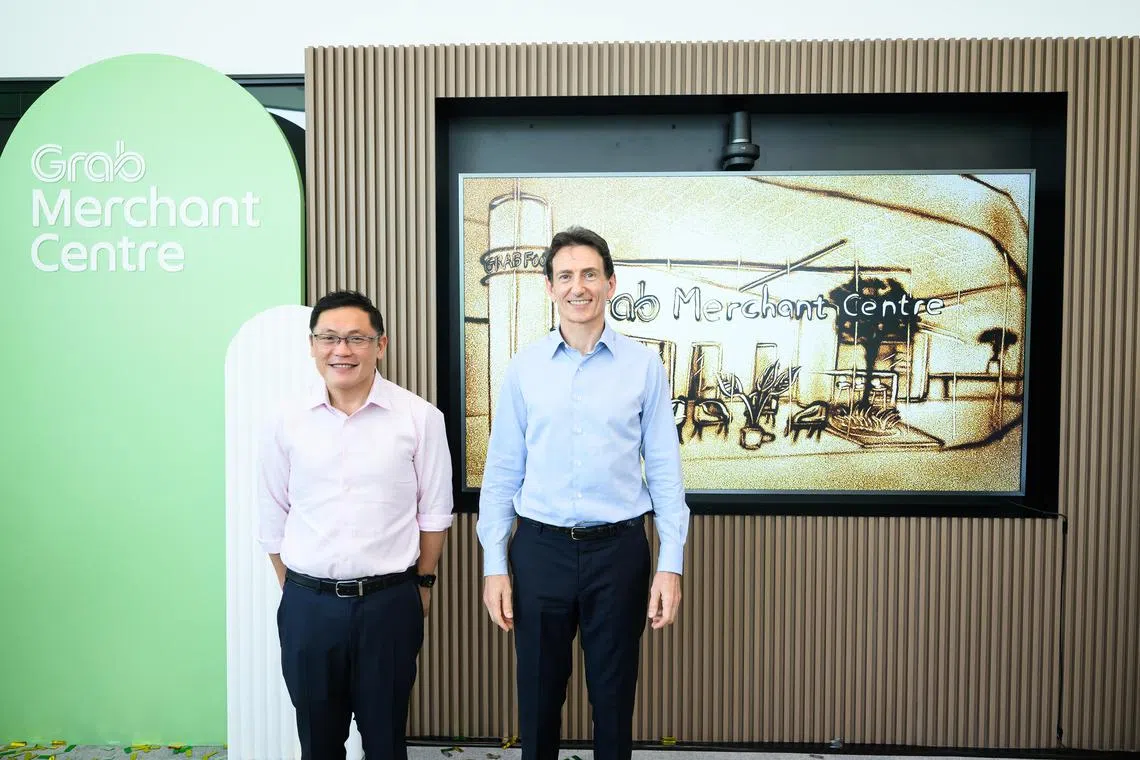Enterprise Singapore chief executive Lee Chuan Teck (left) and Grab chief operating officer Alex Hungate at the Grab Merchant Centre.