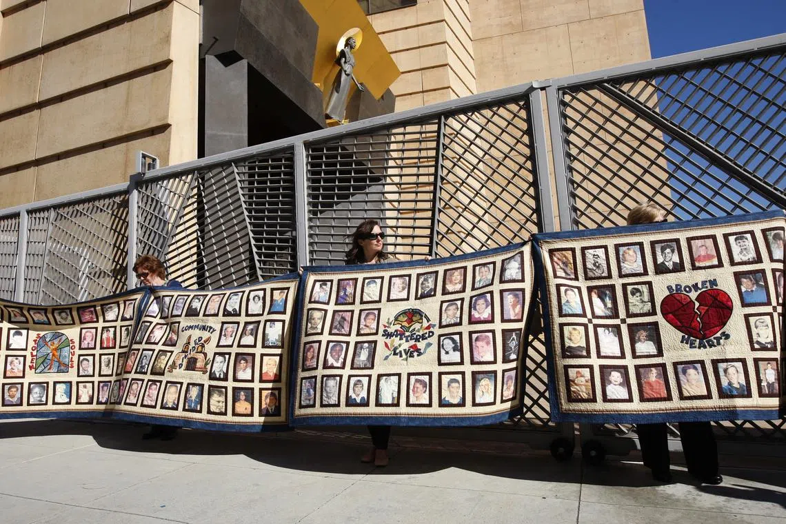 FILE PHOTO: People hold quilts at a press conference outside of Cathedral of Our Lady of the Angels for victims of sexual abuse by priests in the Catholic Archdiocese of Los Angeles in Los Angeles, California, February 1, 2013. REUTERS/David McNew/File Photo