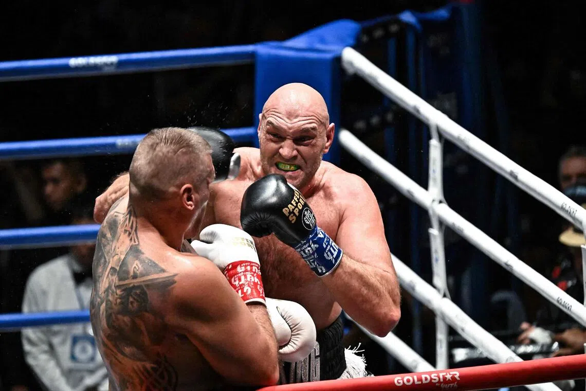 Britain’s Tyson Fury (right) trading blows with Poland’s Mariusz Wach during a charity boxing bout in Pattaya on July 24.
