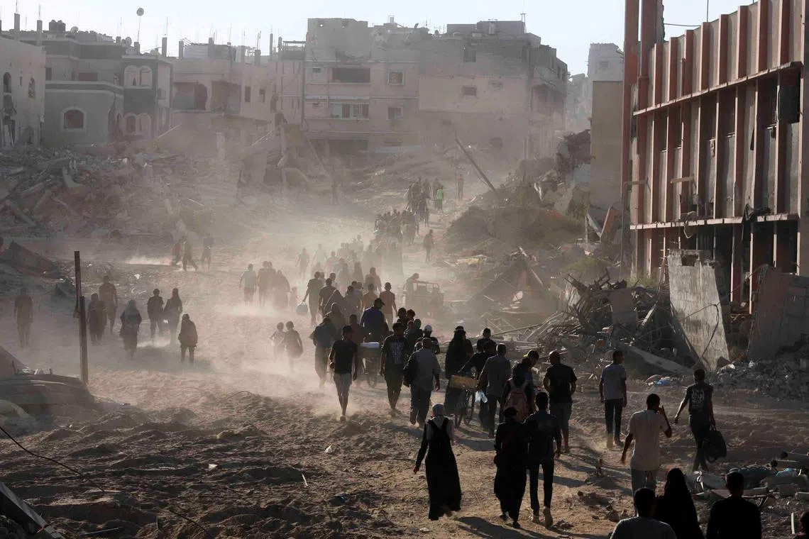 Palestinians making their way as they return to the eastern side of Khan Younis, after Israeli forces pulled out from the area following a raid, amid the Israel-Hamas conflict, in Khan Younis, in the southern Gaza Strip, on July 30, 2024.