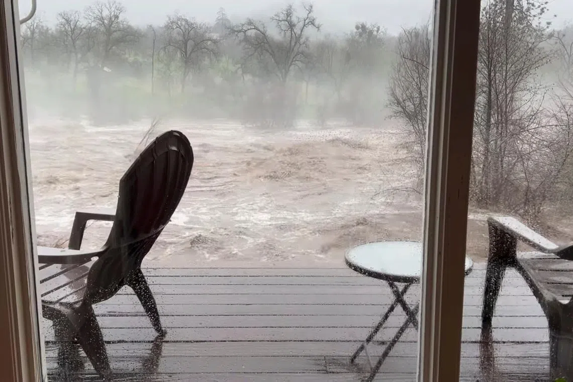 A view shows the overflowing Kern River, as seen from the living room window of a person's house, in Three Rivers, California, U.S., March 10, 2023, in this picture obtained from a social media video. 