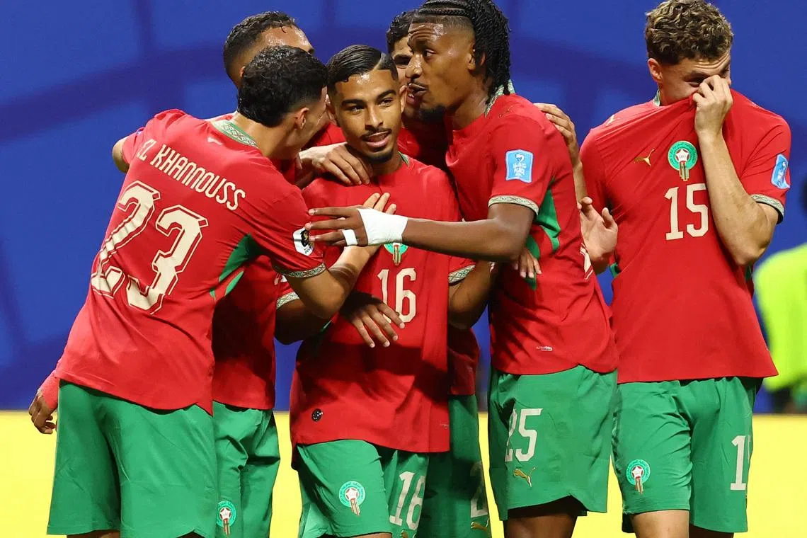 Morocco’s Gessime Yassine celebrates scoring their fourth goal against Haiti with his teammates on June 25.
