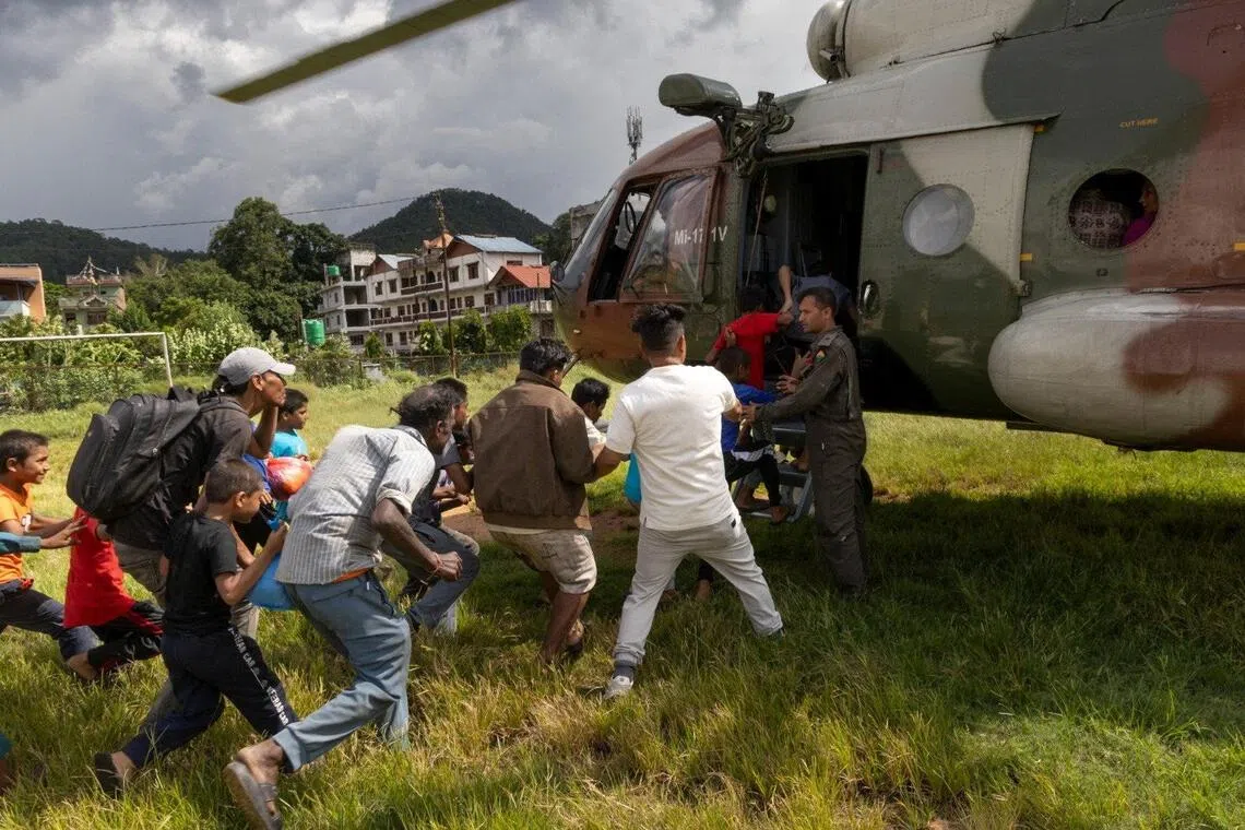 People affected by flash floods and landslides are airlifted in army helicopters.