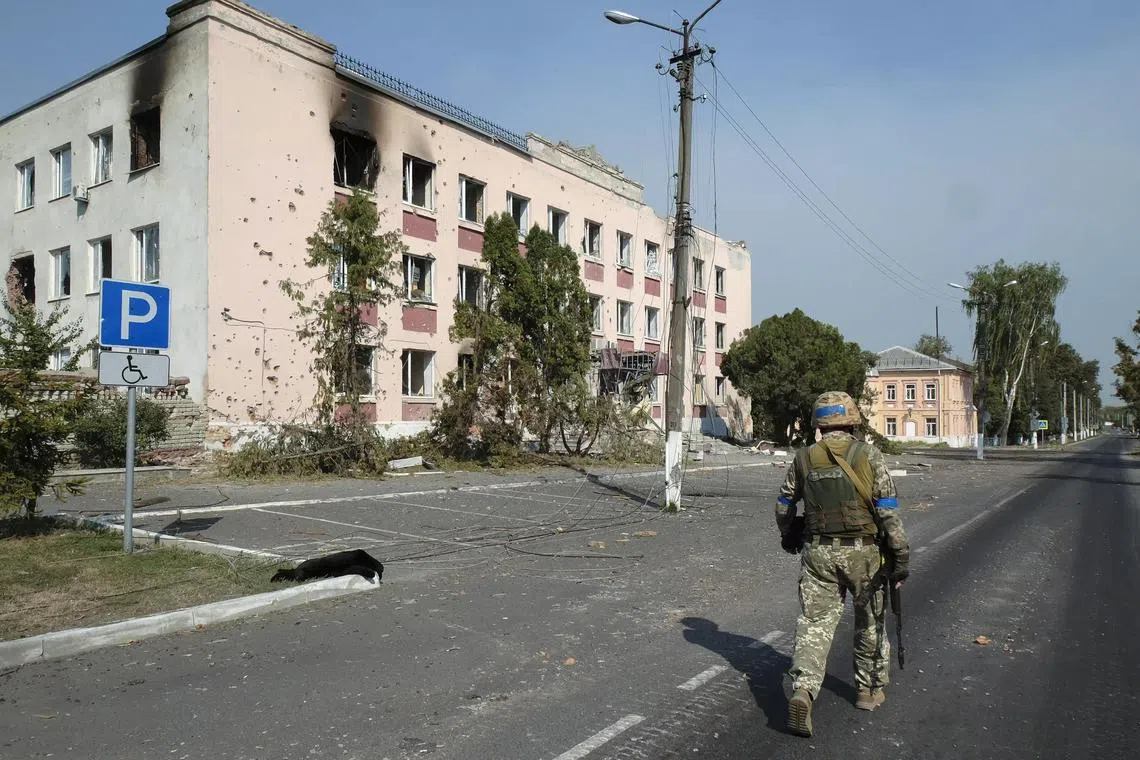 A Ukrainian serviceman walking near damaged buildings in the city centre of Sudzha, in the Ukrainian-controlled territory of Russia's Kursk region, on Aug 21.