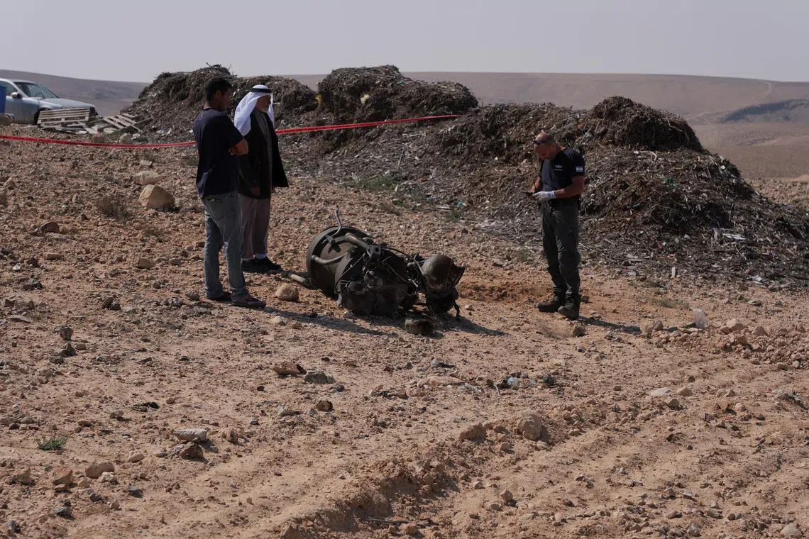 FILE PHOTO: A police officer and residents inspect the remains of a rocket booster that, according to Israeli authorities critically injured a 7-year-old girl, after Iran launched drones and missiles towards Israel, near Arad, Israel, April 14, 2024. REUTERS/Christophe van der Perre/File Photo